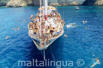Uczniowie języka angielskiego skaczący do wody z łodzi na Malcie