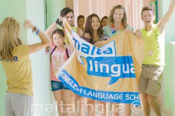 Grupa uczniów języka angielskiego z flagą