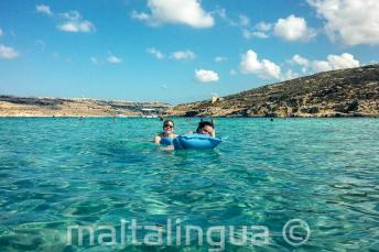 Studenci szkoły językowej pływają w wodach Blue Lagoon na Comino
