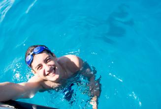 Student pływa obok statku w wodach Comino.